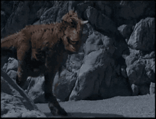 a dinosaur is standing on a rocky hillside