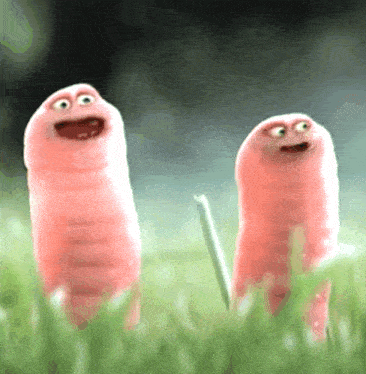 two pink worms are standing next to each other in a field