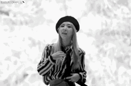 a black and white photo of a woman wearing a striped shirt and a black beret
