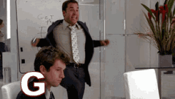 a man in a suit and tie is standing in front of a whiteboard that says get the f