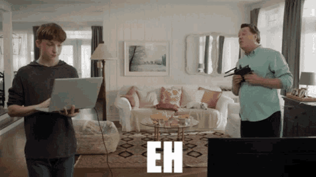 a man is holding a gun while a boy holds a laptop in a living room with the word eh on the screen