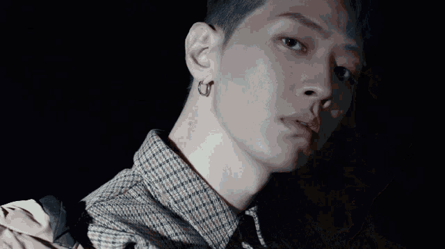 a young man with blue hair and a plaid shirt