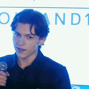 a young man is holding a microphone in front of a sign that says o and t.
