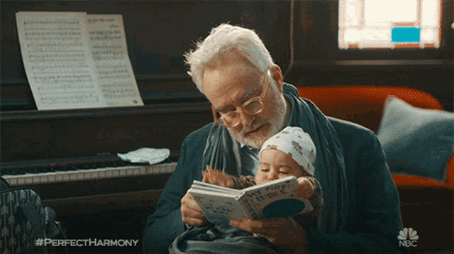 an older man is reading a book to a baby with the hashtag perfectharmony on the bottom right