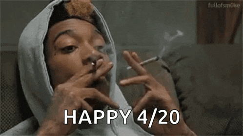 a man in a hoodie is smoking a cigarette and says `` happy 4:20 '' .