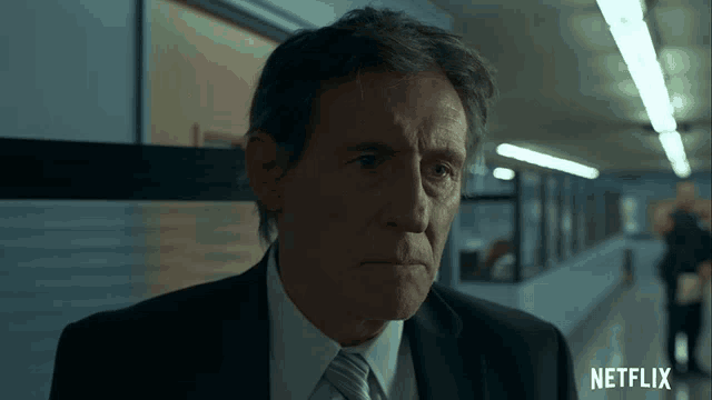 a man in a suit and tie with a netflix logo on the bottom