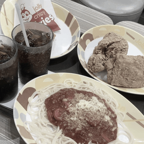 a packet of jolly crispy fries sits next to a plate of spaghetti