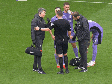 a soccer player with the number 9 on his back talks to a referee