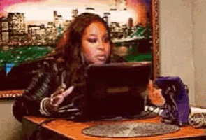 a woman is sitting at a table using a laptop computer