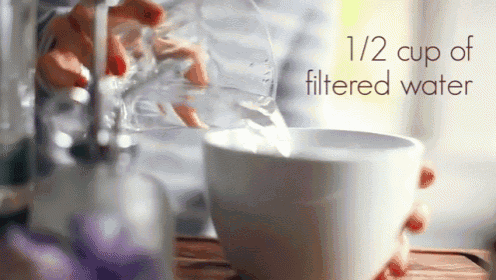 a person pouring water into a cup with the words 1/2 cup filtered water below it