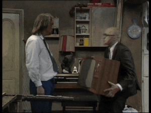 a man in a suit is holding a wooden box with the letter a written on it