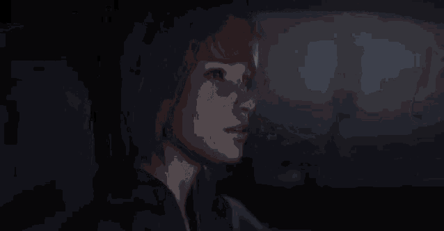 a woman is sitting in the back seat of a car and looking out the window .