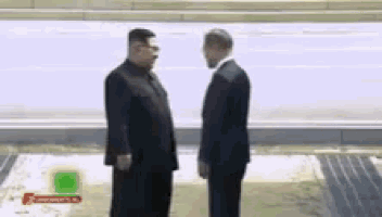 two men in suits are standing next to each other and talking