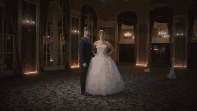 a man in a suit and a woman in a wedding dress are standing next to each other