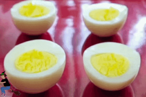 four hard boiled eggs are cut in half and sitting on a red plate .