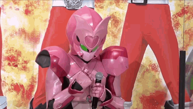 a pink robot with green eyes is holding a microphone in front of a fire background