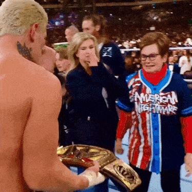 a woman wearing an american nightmare shirt stands next to a shirtless man
