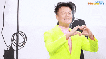a man in a neon yellow suit is dancing in front of a camera .