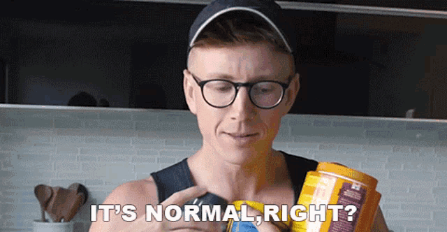 a man wearing glasses and a hat is holding a can and asking if it is normal right