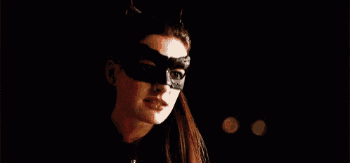 a woman in a catwoman costume is wearing a mask and looking to the side .