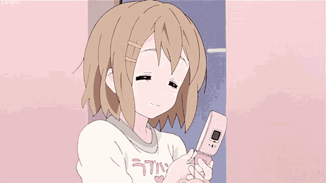 a girl is holding a pink flip phone with the word latin on it