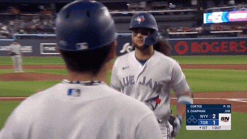 a blue jays player is talking to another player on the field