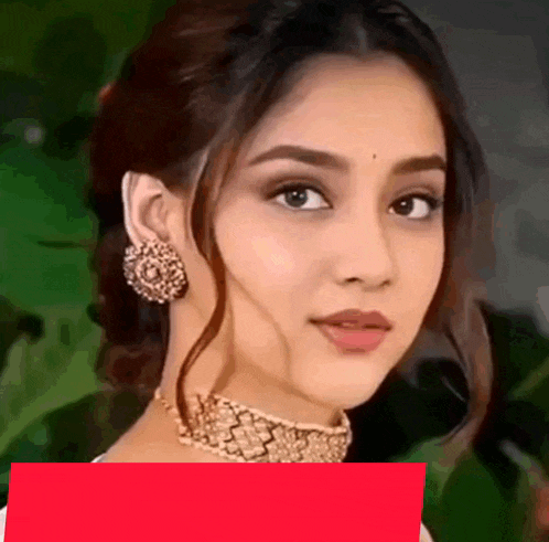 a woman wearing a choker and earrings looks at the camera