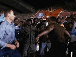 a man in a blue shirt is standing in a crowd of people