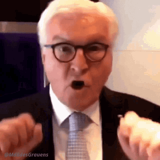 a man in a suit and tie is making a face