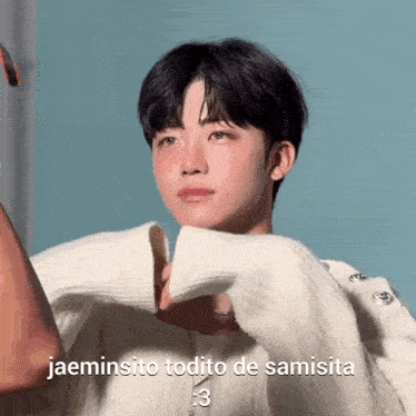 a young man wearing a white sweater with the words jaeminsito todito de samsita