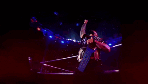 a man in a wrestling ring is wearing a blue belt