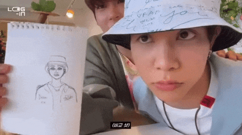 a man in a bucket hat is holding up a drawing of a man