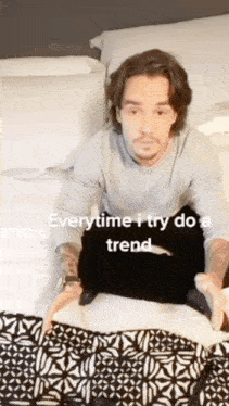 a man is sitting on a bed with the words everytime i try do a trend on the bottom