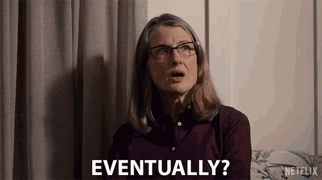 a woman with glasses is sitting on a couch and says eventually