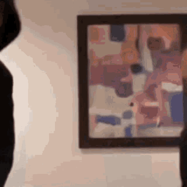 a woman is standing in front of a painting on a wall .