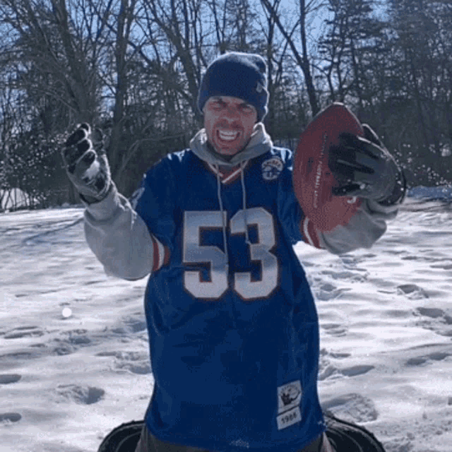 a man in a blue jersey with the number 53 on it is holding a football