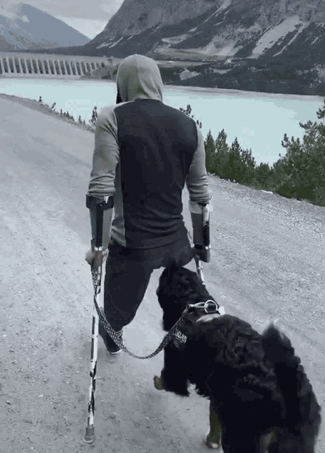 a man with a prosthetic leg is walking a dog on a leash that says ' jacob ' on it