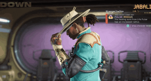 a man in a cowboy hat stands in front of a screen that says down