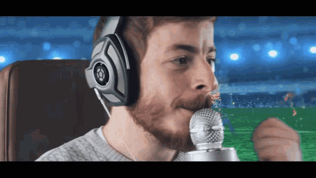 a man wearing headphones is singing into a silver microphone