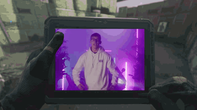 a person is holding a tablet with a picture of a man in a hoodie that says netflix on it