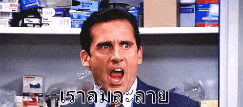 a man in a suit and tie is making a funny face in front of a shelf with boxes on it ..