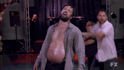 a man with a very large belly is dancing on a stage in front of a fx logo .