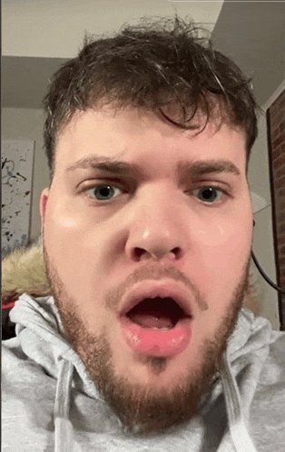 a man with a beard is making a funny face with his mouth wide open