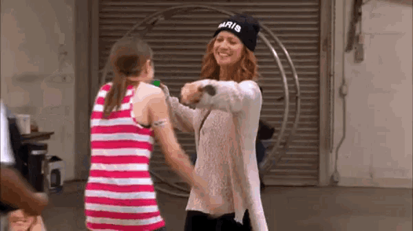 a woman in a black hat is hugging a little girl .