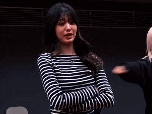 a woman wearing a striped shirt with a tommy hilfiger logo on it