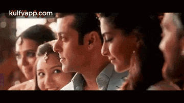 a group of people are standing next to each other and looking at a man .