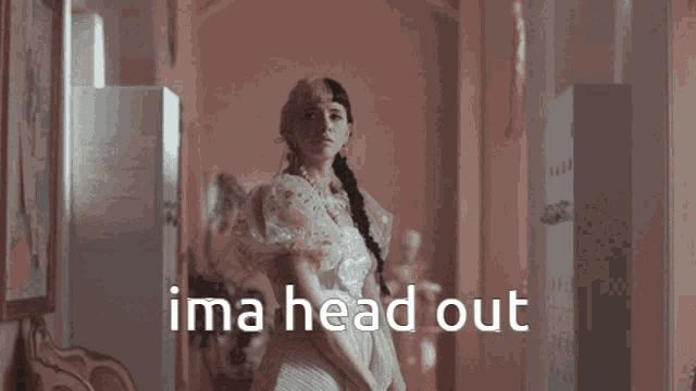 a woman in a dress is standing in a hallway with the words ima head out written on the bottom