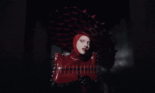 a woman in a red latex outfit with spikes on her head