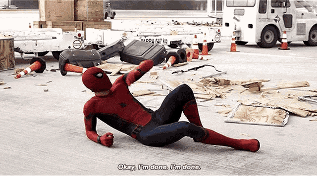 a man in a spiderman costume is laying on the ground and saying okay i 'm done i 'm done