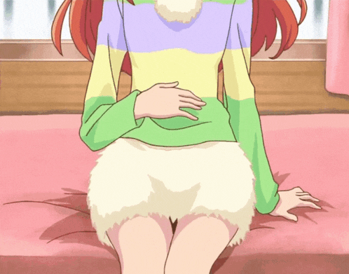 a girl with red hair is sitting on a bed wearing a colorful sweater